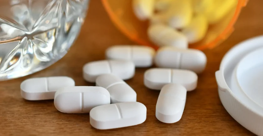 Narcotic opioid pain pills spilled next to a prescription bottle