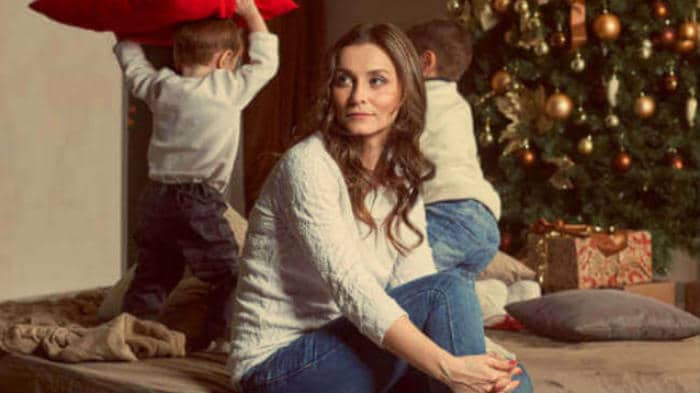 woman watching her kids play at Christmas