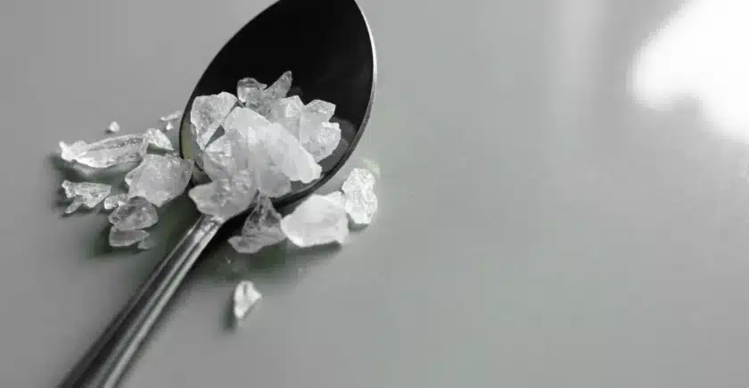 Close-up of methamphetamine crystals on a spoon, representing drug abuse