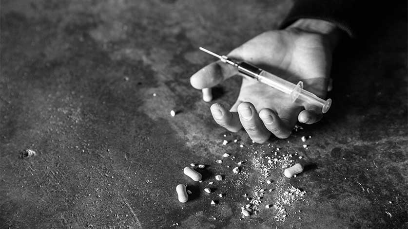 hand holding a syringe - Drug Addiction & Overdose Deaths In The U.S.