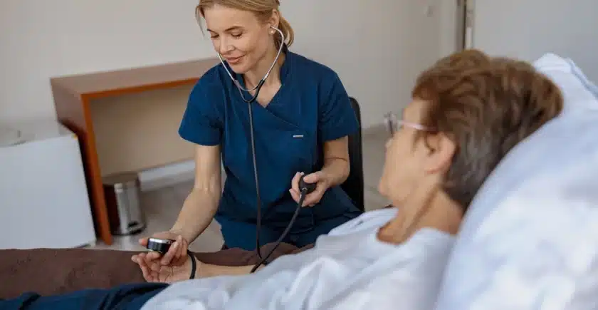 Female nurse checking the blood pressure of a senior woman