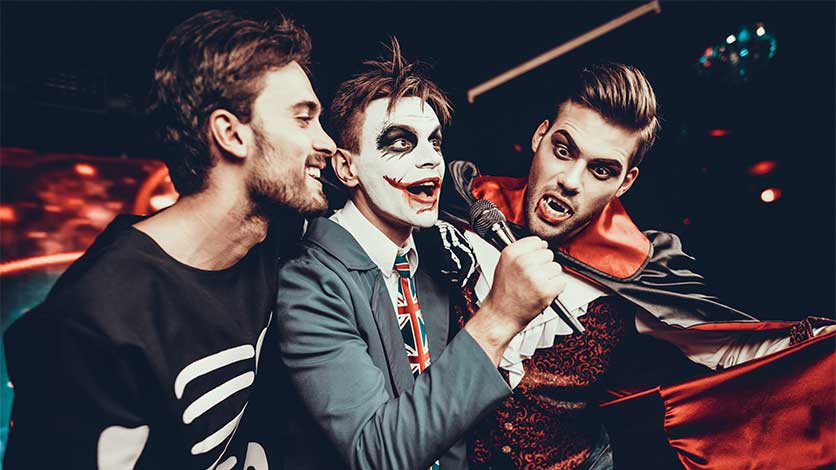 group of guys singing karaoke at a halloween party - Halloween Ideas For The Sober Curious
