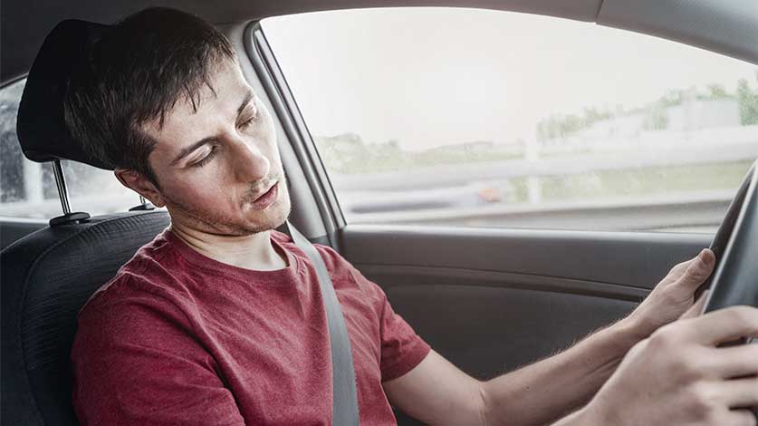 Man nodding off at the wheel of a car - Nodding Off Vs. Drug Overdose